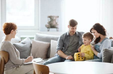 Young Married Couple With Son During Family Therapy With Counsel Physical Therapist Exercises